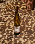 Wine bottle on a wooden surface with patterned shadows