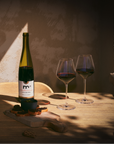 Wine bottle and glasses on a wooden table with warm lighting
