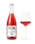 Bottle and glass of red NON alcoholic beverage on a white background