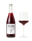 Bottle and glass of red wine with 'NON' label on a white background