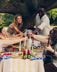 Group of people enjoying a meal outdoors under a tree