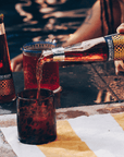 Person pouring a bottle of Phony Espresso Negroni into a glass