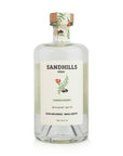 Clear glass bottle of Sandhills elixir with a decorative label on a white background