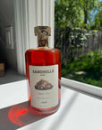 Bottle of Sandhills elixir on a windowsill with a garden view