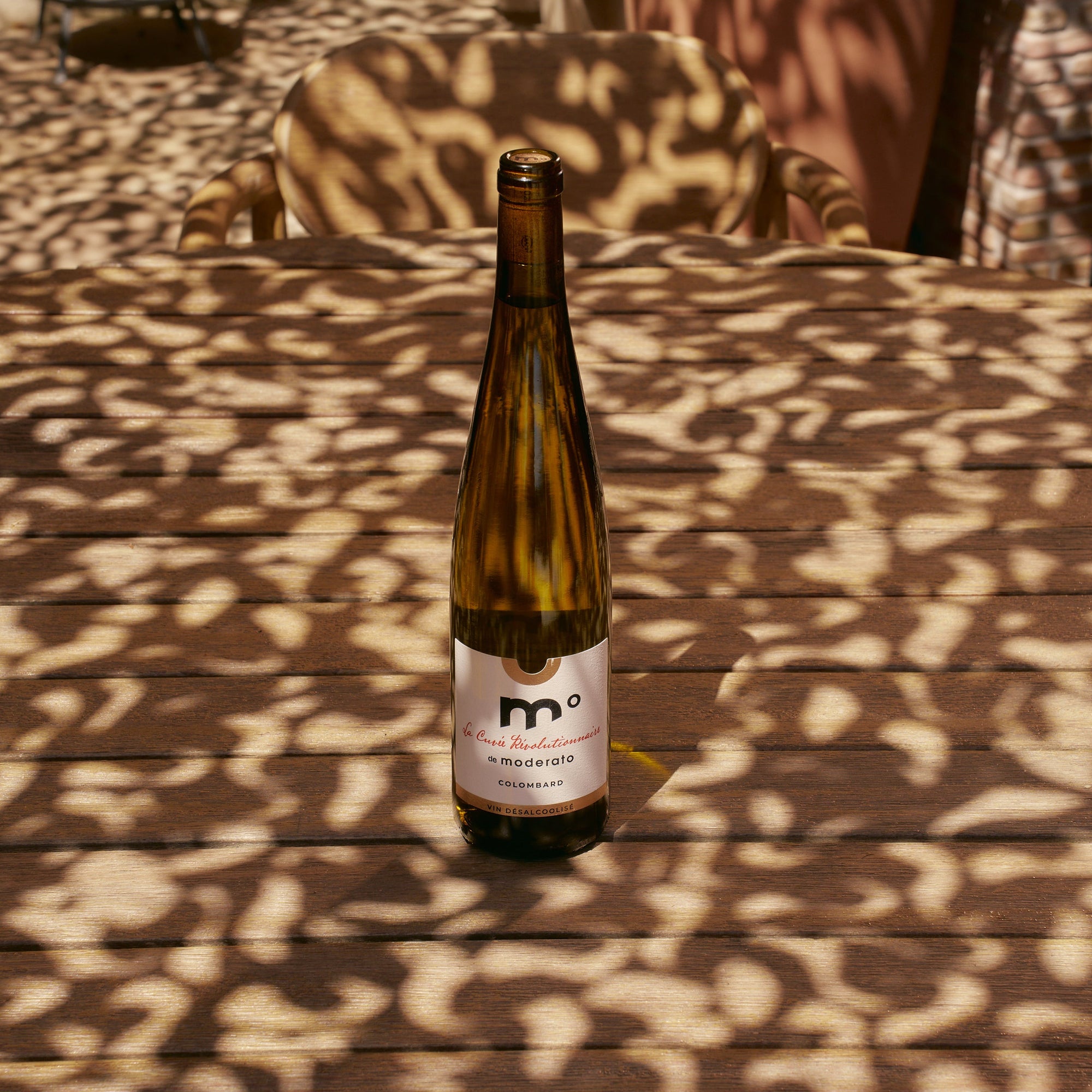 Wine bottle on a wooden surface with patterned shadows