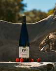 Wine bottle with a label on a stone surface with tomatoes and a natural background