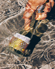 Hand holding a bottle labeled 'Macky White Vegas' underwater with clear water.