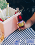 Person holding a bottle of Fentimans at a table with a pink cooler, snacks, and playing cards.