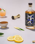 Bottle of Absolut Vodka with cocktails and garnishes on a light background