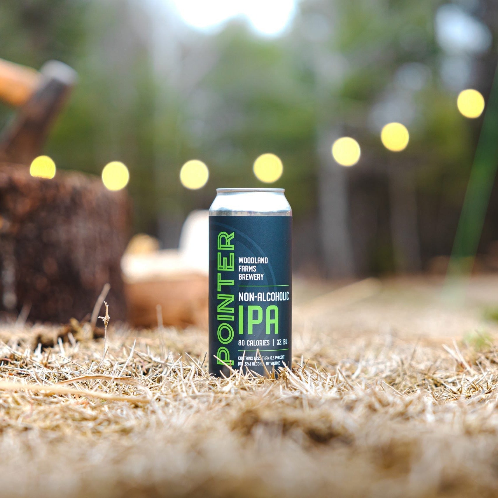 Non-alcoholic IPA can on hay with blurred outdoor background